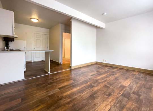 A room with wooden floors and white walls. at Zindorf, Seattle, WA, 98104
