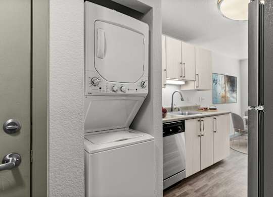 A white dishwasher is in a kitchen with a door open.