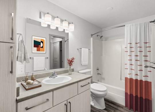 A bathroom with a white toilet, sink, and shower curtain.