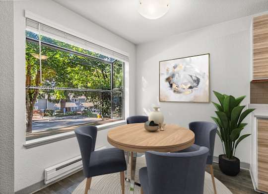 A room with a table, chairs, and a painting on the wall.