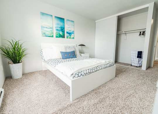 A bedroom with a bed, a plant, and a painting on the wall. at The Aviator, Washington, 98055
