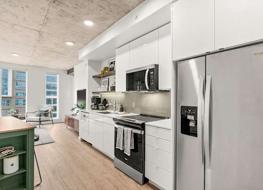 A modern kitchen with stainless steel appliances and white cabinets.