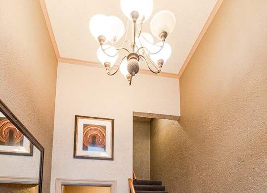 A staircase with a wooden handrail and a chandelier hanging from the ceiling. at Edwards on Fifth, Washington