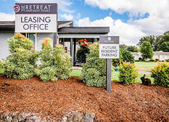 A sign for a leasing office and future resident parking in front of a building. at The Retreat, Sumner, Washington