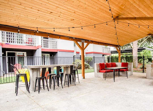 A wooden patio with a table and chairs under a roof. at Notch 8, Tacoma, Washington