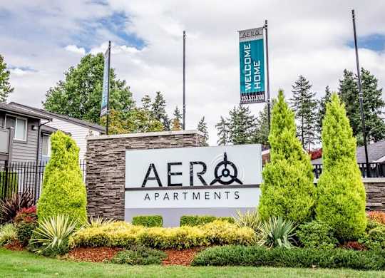 A sign for Aero Apartments is displayed in front of a building.