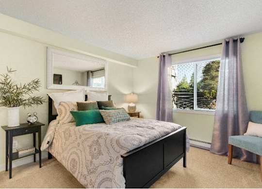 A bedroom with a large bed and a chair. at The Retreat, Sumner