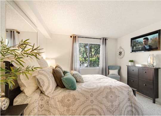 A bedroom with a large bed and a painting of a man on the wall. at The Retreat, Washington