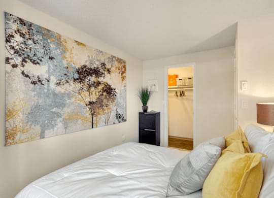 A bedroom with a large painting on the wall and a bed with white sheets and yellow pillows. at The Retreat, Washington