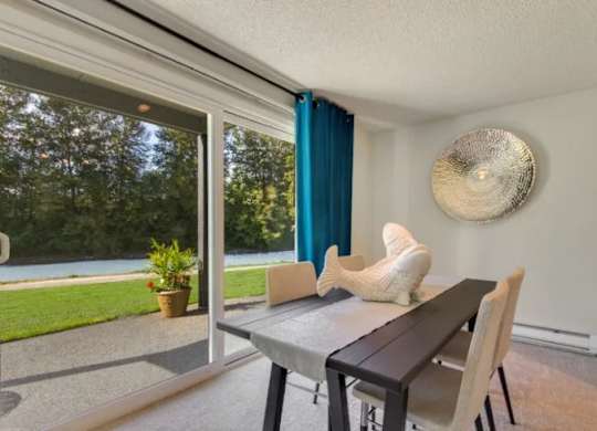 A dining room with a table and chairs and a view of the outdoors. at The Retreat, Washington, 98390
