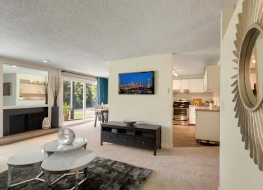 A modern living room with a grey sofa and a TV mounted on the wall. at The Retreat, Sumner, WA, 98390