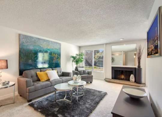 A living room with a grey couch, a coffee table, a fireplace, and a painting on the wall. at The Retreat, Washington, 98390