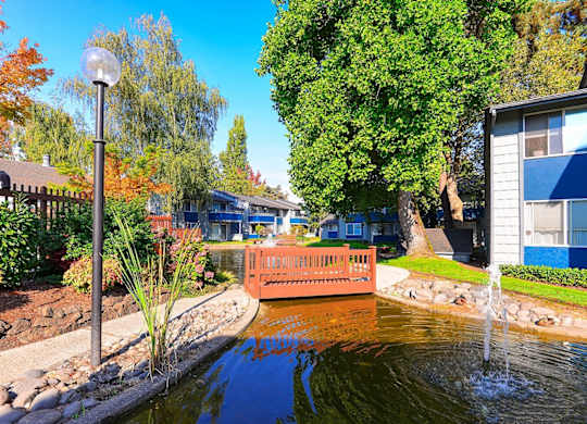 A small boat is floating on a canal in a residential area. at The Lakes at Fife, Fife, WA, 98424