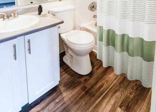 A white toilet sits next to a sink in a bathroom.