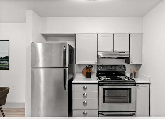 A modern kitchen with a stainless steel refrigerator, stove, and cabinets.