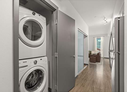 A modern laundry room with a washer and dryer built into the wall.