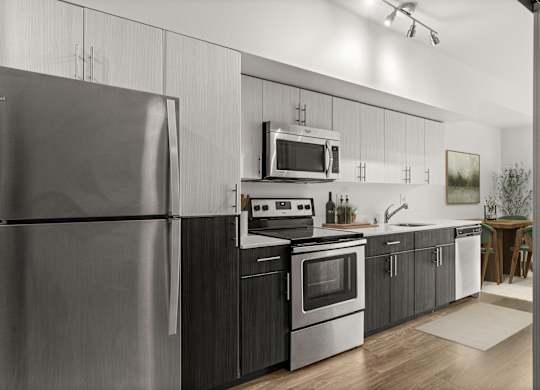 A modern kitchen with a stainless steel refrigerator and black cabinets.