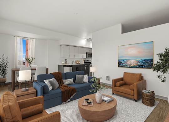 A living room with a blue couch, brown armchair, and a painting on the wall.