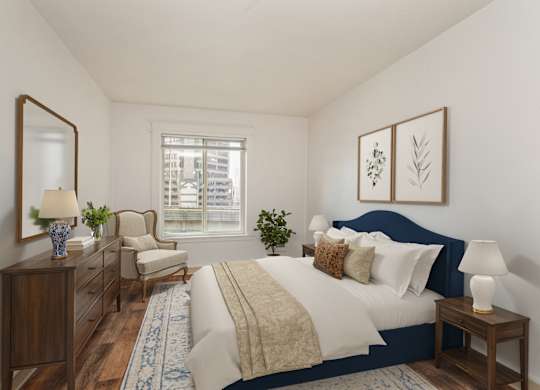 A bedroom with a bed, chair, and a mirror.
