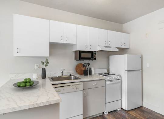 A kitchen with white appliances and cabinets.