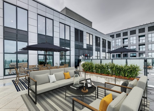 a terrace with couches and chairs and a table with umbrellas at BLVD Beltline, Calgary, AB