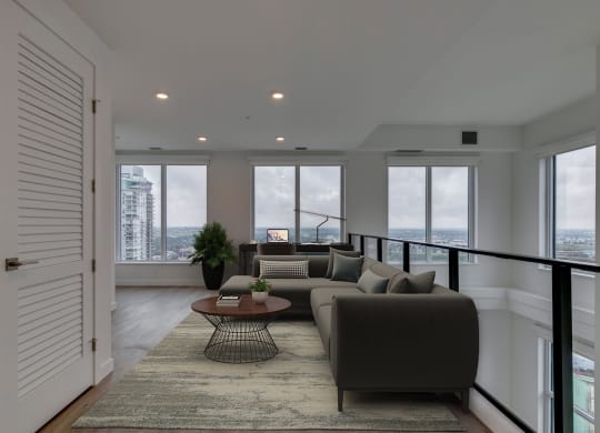 a living room with a couch and a coffee table in front of windows at BLVD Beltline, Calgary, AB