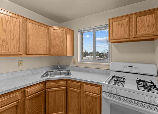 A kitchen with wooden cabinets and a white stove at Kensington House, Kensington, 20895