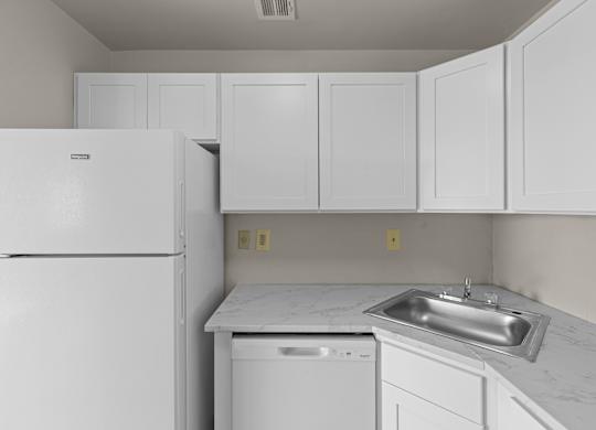A white kitchen with a refrigerator, dishwasher, and a sink at Kensington House, Maryland 20895