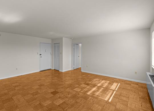 A room with wooden flooring and white walls at Kensington House, Kensington, 20895