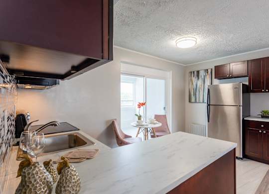A kitchen with a marble countertop and a refrigerator at The Lawrence Apartments, Greenbelt, 20770