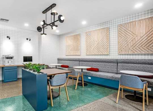 A modern office space with a blue accent wall and wooden furniture.