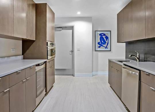 A kitchen with brown cabinets and a white counter top.
