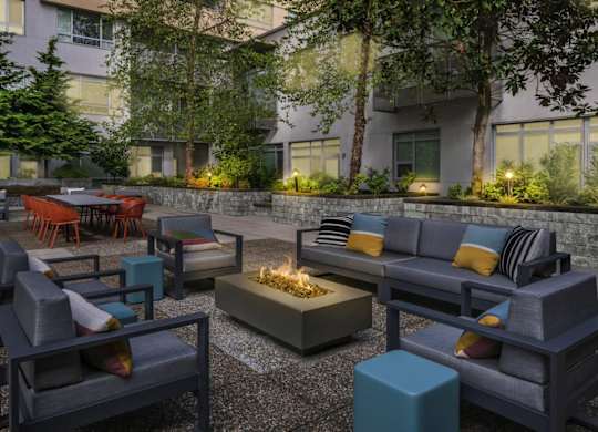 A modern outdoor seating area with a fire pit in the center.