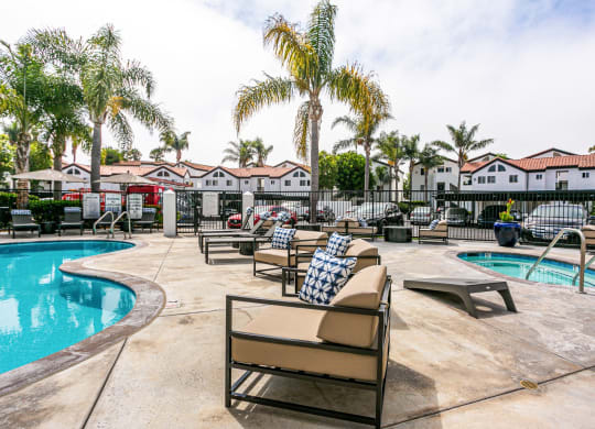 a resort style pool with chairs and palm trees