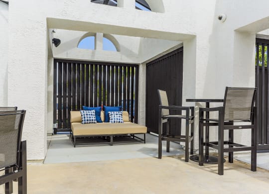 a patio with a couch and tables and chairs