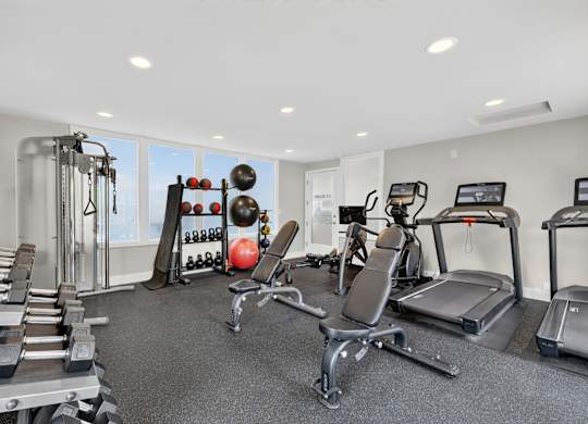A well-equipped gym with a variety of exercise machines and weights.