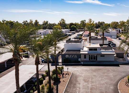 A view of a parking lot with a building that has the word AVIA on it.