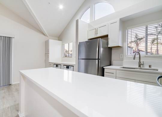 A modern kitchen with a large island and stainless steel appliances.