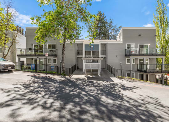 an apartment building with a parking lot and trees