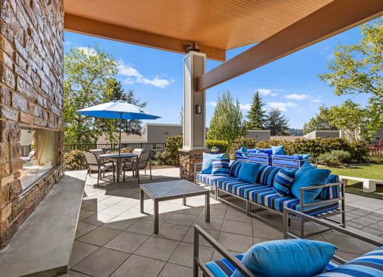 a covered patio with blue chairs and umbrellas