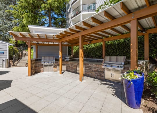 a patio with a barbecue grill and a pergola