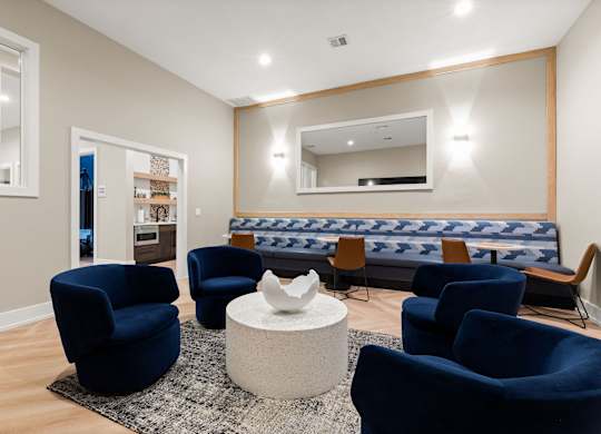 A living room with blue chairs and a white coffee table.