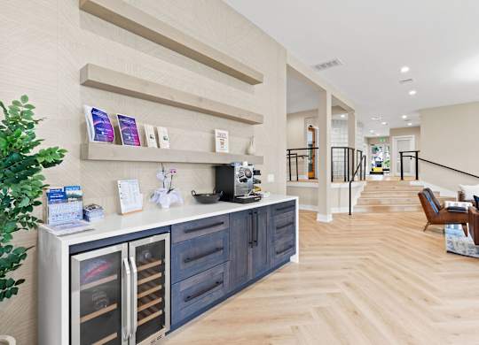 A modern kitchen with a wooden floor and a white wall.