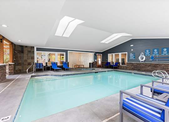 A large indoor swimming pool with a diving board.