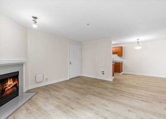A room with a fireplace and wooden flooring.