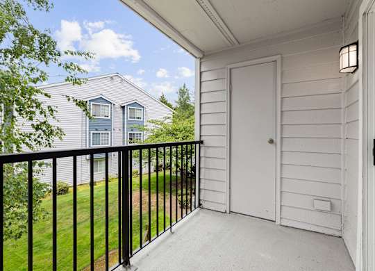 A white door is on the porch of a house.