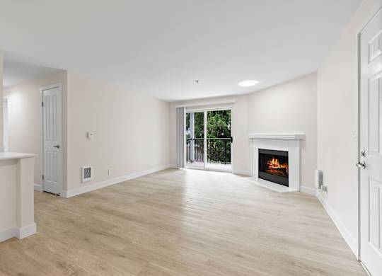 A spacious living room with a fireplace and sliding glass doors.