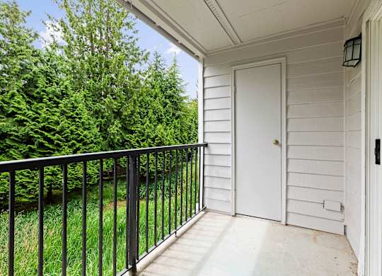 A white door is on the right side of a porch.