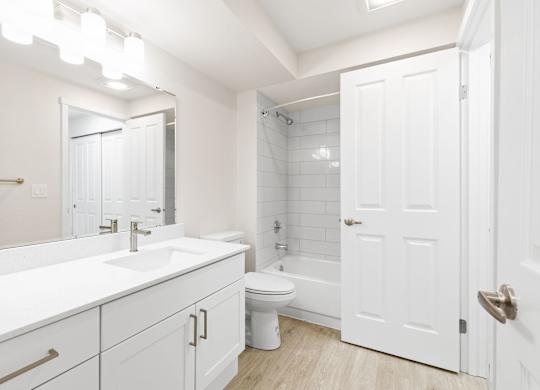 A white bathroom with a toilet, sink, and bathtub.
