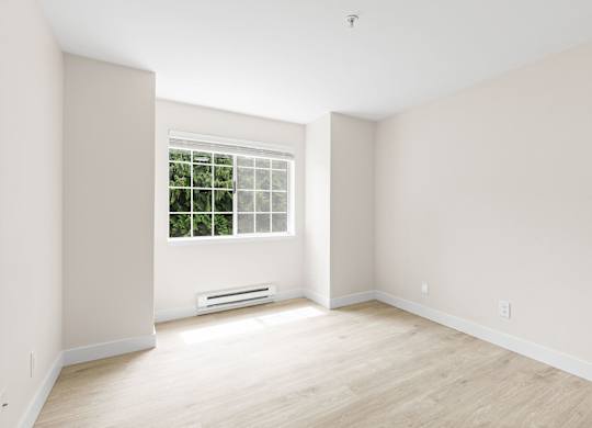 A room with a window and a wall-mounted air conditioner.